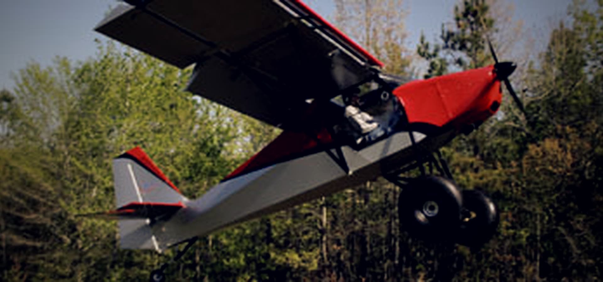 A STOL aircraft in a steep climb-out over the treeline near KTOC.